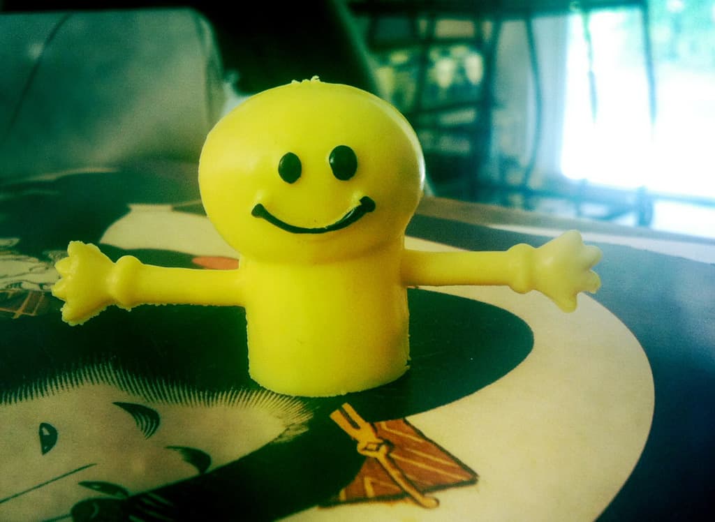 A yellow smiley-face finger puppet